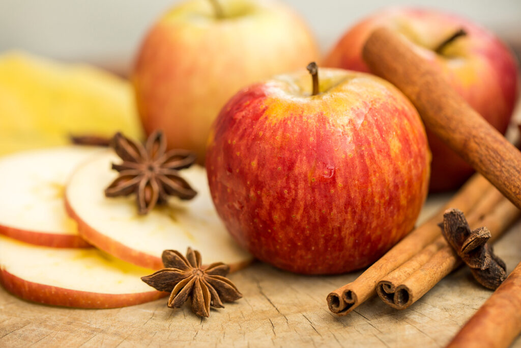 Fall Foods That Are Good for Your Teeth - Apples with star anise. Autumn composition with leaves and apples.