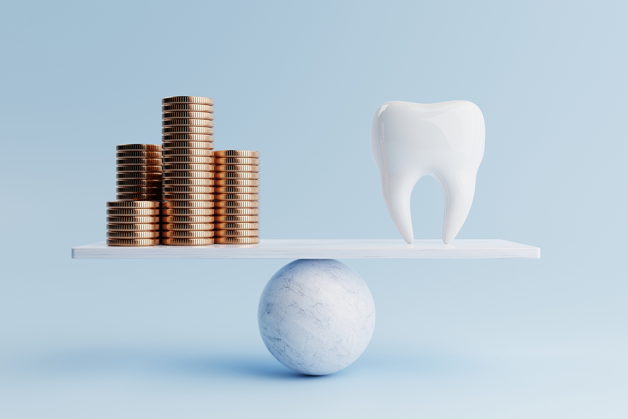 Dental Benefits - Dental tooth and golden coin on balancing scale on blue background.