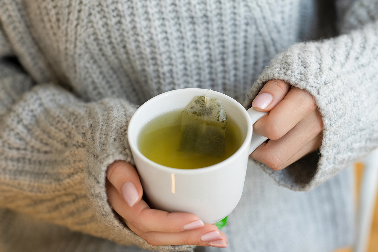 Tooth-Friendly Hot Drinks - Female hands with cup of hot tea