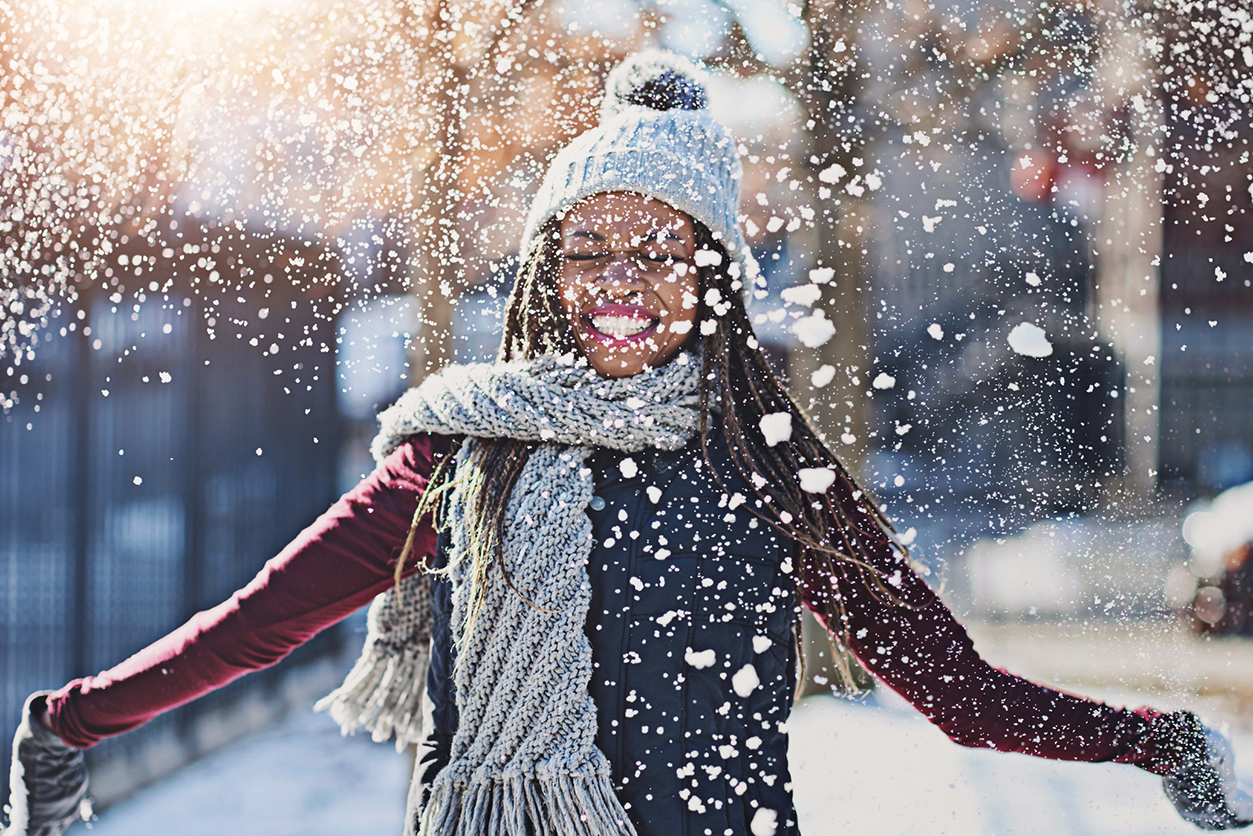 Playful, snow and black woman in city, cold and winter with fun, happiness and vacation in New York. Person, outdoor and season with girl, cheerful and weather with break, urban town and joy