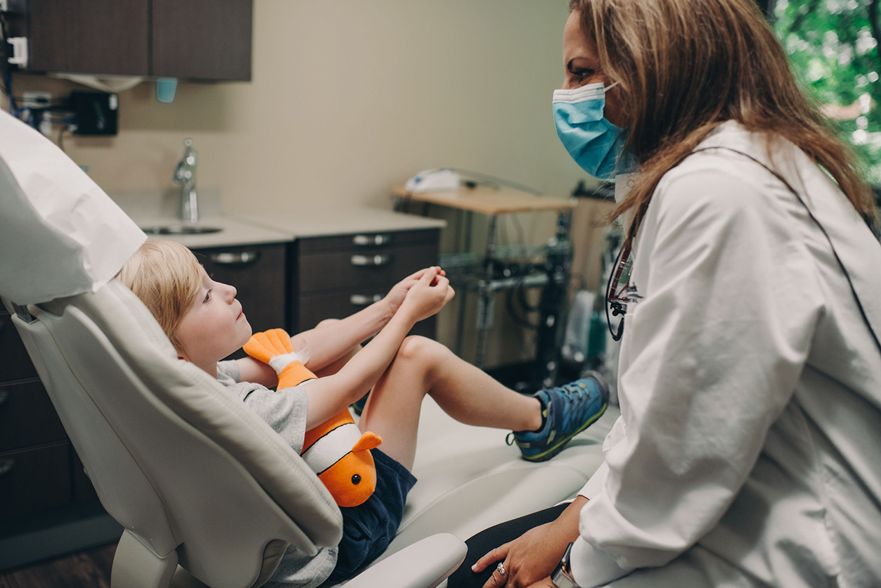 woman doctor talking to child patient