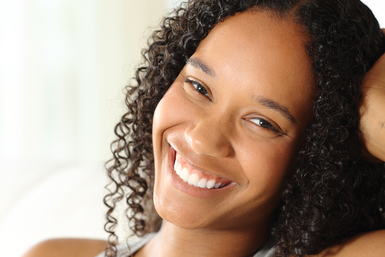Teeth Whitening in Plymouth - Portrait of a happy black woman with perfect smile posing at home