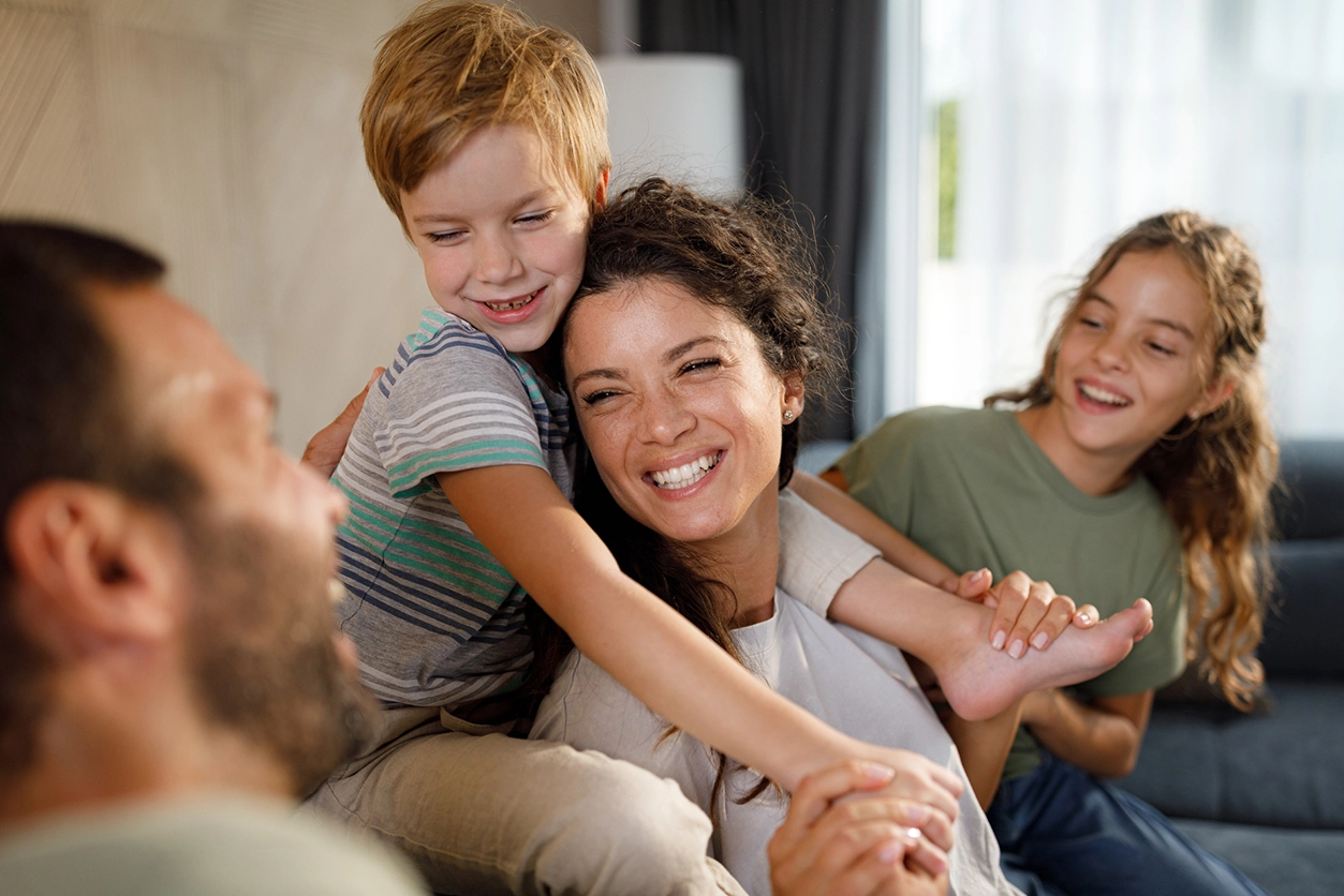 Golden Valley Moms - Mom sitting w/ family laughing, smiling