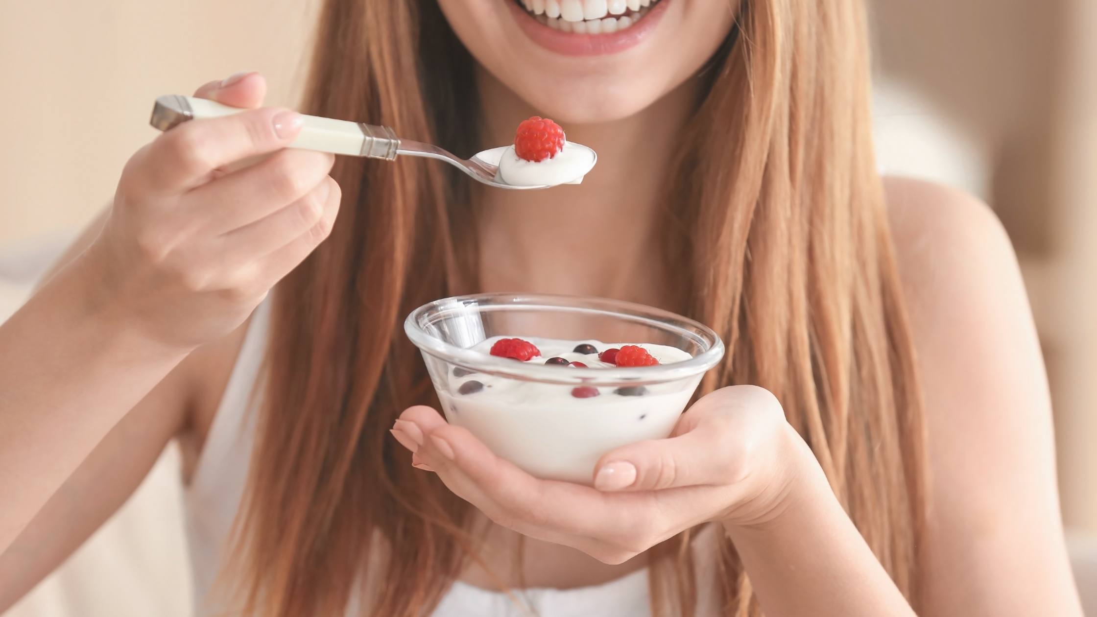 Woman eating yogurt for the oral health benefits