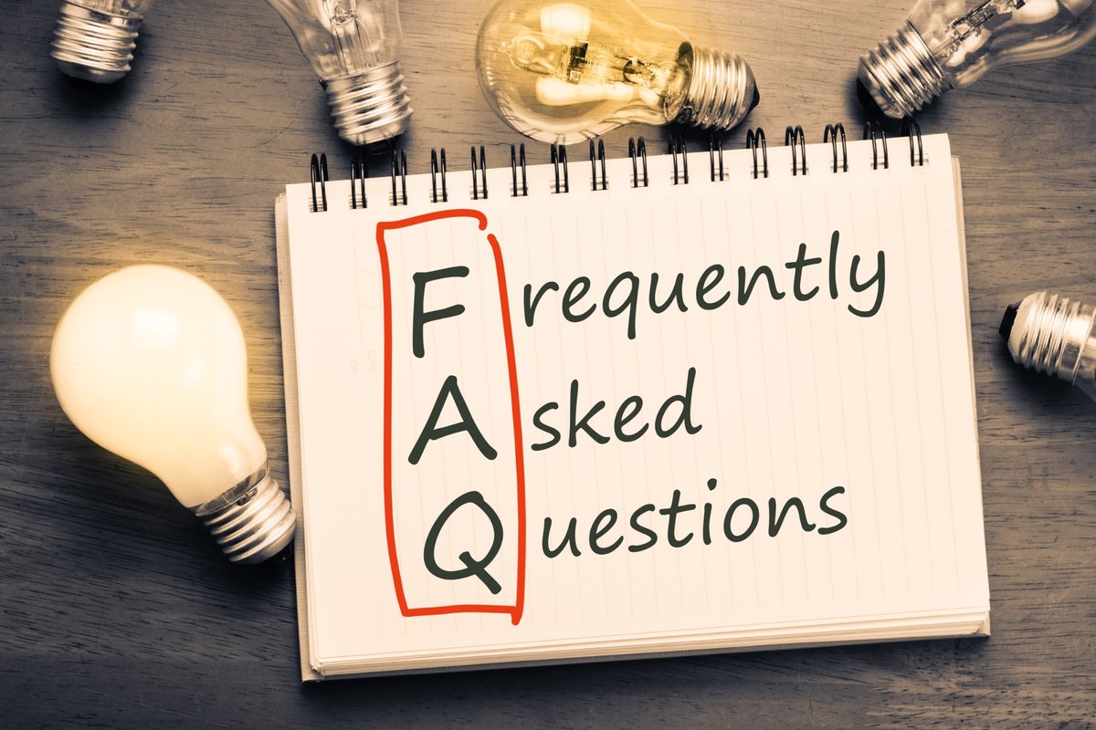 Notebook with the words FAQ — frequently asked questions — surrounded by lightbulbs.