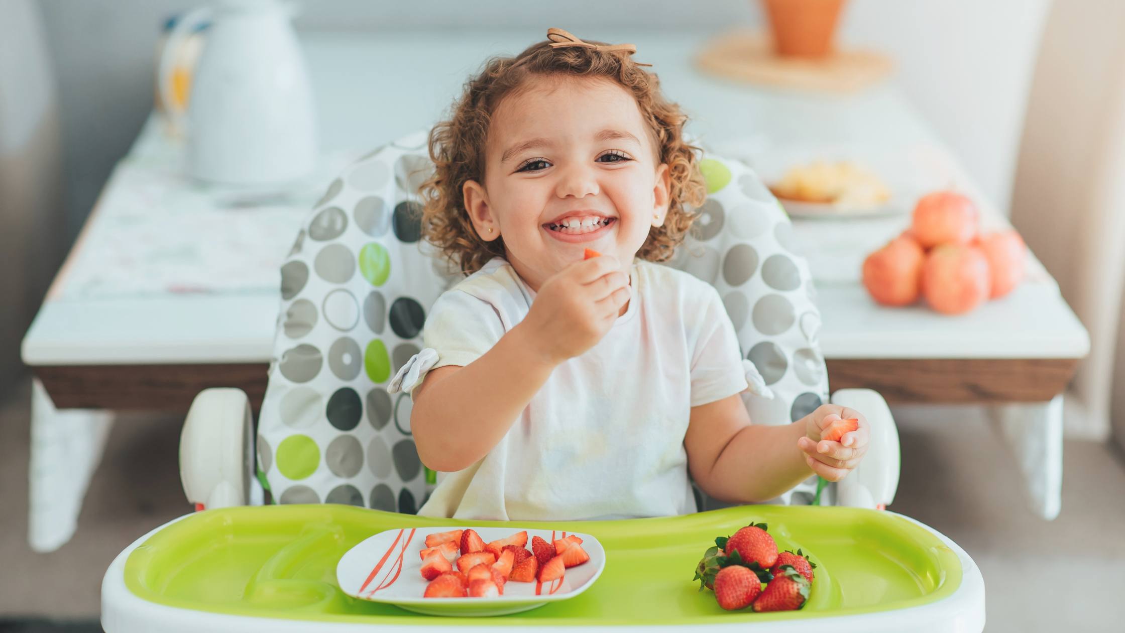 smiling young child eating a health snack for her body and smile