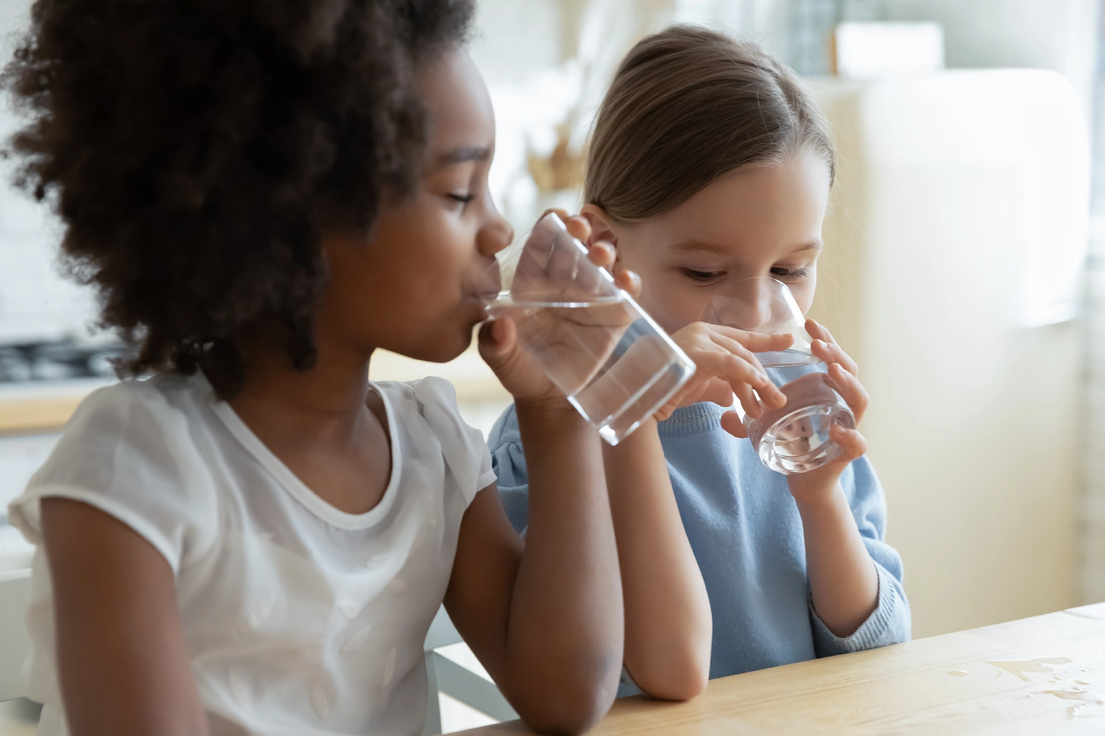 Young girls drinking water with fluoride safely added to it