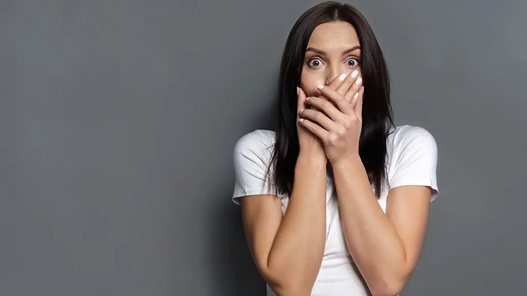 Woman covering mouth in fear of a deep dental cleaning