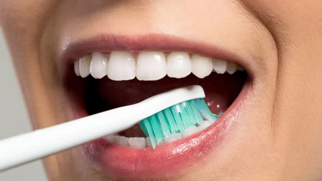 Up close of white teeth being brushed 
