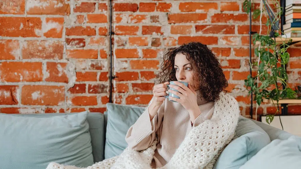 Woman sipping coffee on her couch