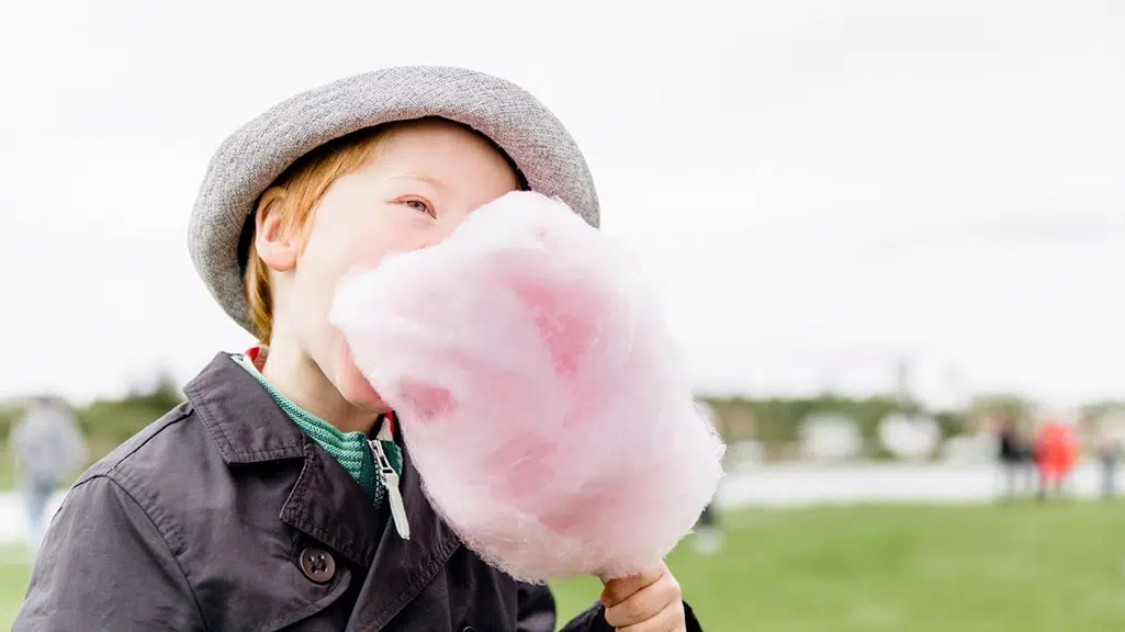 Young boy eating cotton candy