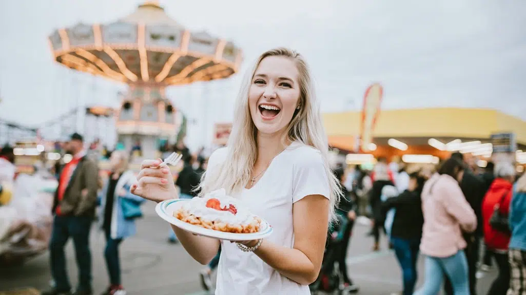 woman at fair eating funnel cake